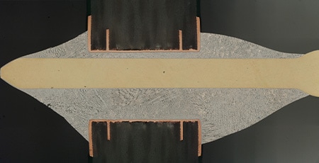 Gekoppeld beeld van een dwarsdoorsnede van een gesoldeerde connectorpin